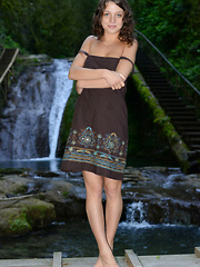 Cute Nensi B showcasing her delightfully petite body against a refreshing view of the cascading waterfalls.